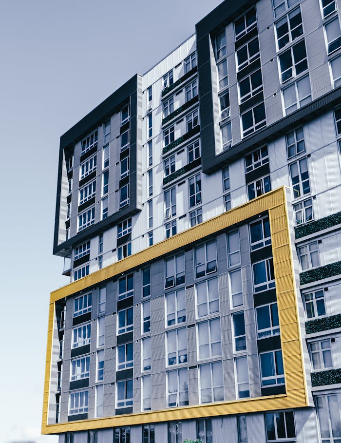Low-angle view of a modern urban high-rise building facade with geometric design.